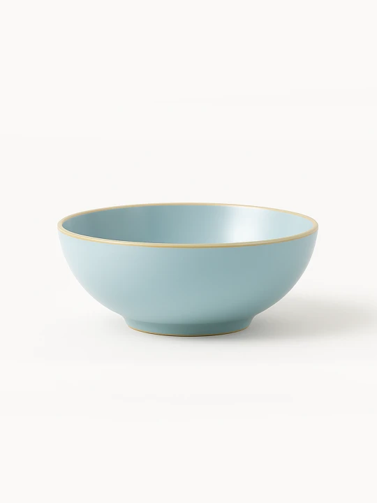 A round ceramic bowl with a smooth matte finish in light blue features a subtle, natural-toned rim.