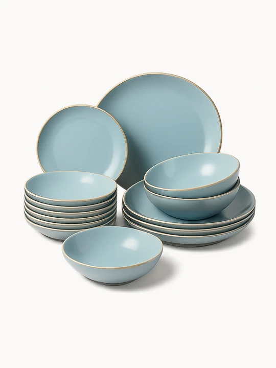A multi-piece ceramic dinnerware set in a matte light blue color with a thin gold rim is neatly stacked and arranged. The collection includes various sizes of dinner plates, side plates, and bowls.