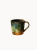Ceramiczny kubek o rustykalnym designie, pokryty gładkim szkliwem w odcieniach ziemistej zieleni, które przechodzą w naturalną, brązową podstawę, na jednolitym białym tle.