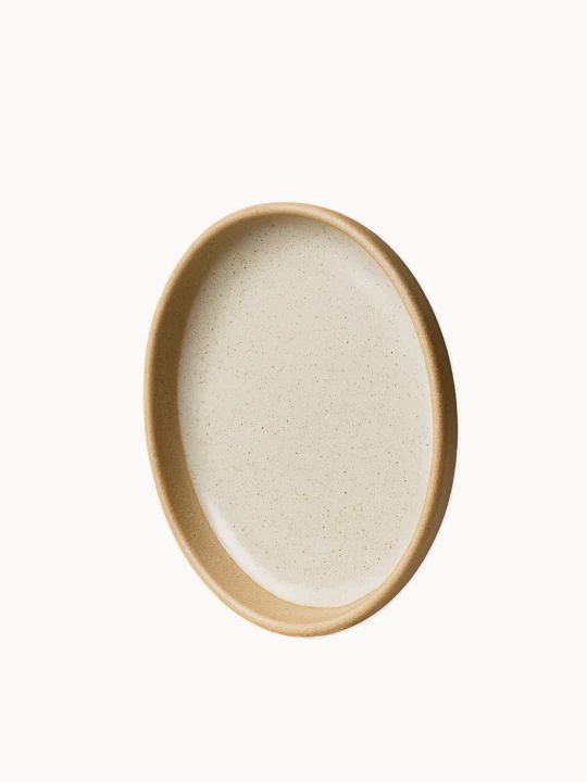 A top-down view of a round ceramic plate featuring a speckled, light grey glazed interior and a thick, unglazed natural terracotta rim. The plate is featured in a vertical position on a plain white background.