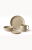 A minimalist stoneware dinnerware set in a speckled beige finish with a natural brown rim is arranged against a plain white background. The collection features a large dinner plate, a medium bowl, a small saucer, and a matching mug.