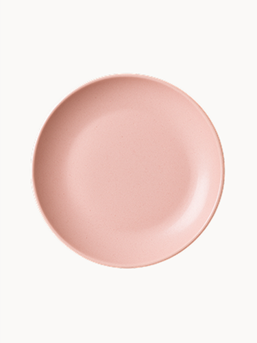 A top-down view of a matte, pastel pink ceramic plate.