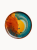 A top-down view on a flat ceramic plate with a vibrant, artistic glaze with a fiery orange center bleeding into a deep teal border.