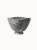 A ceramic bowl with a speckled black and white texture with subtle horizontal ribbed lines, on a plain white background. The deep bowl has a unique, square-like curved rim.