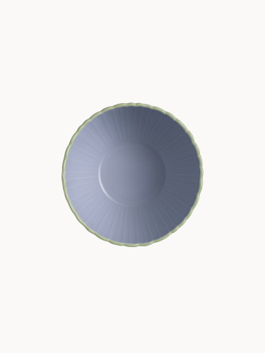 A top-down view on a two-toned ceramic bowl with a finely ribbed, mint  exterior and a smooth lavender interior, on a plain background.