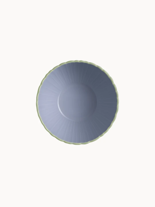 A top-down view on a two-toned ceramic bowl with a finely ribbed, mint  exterior and a smooth lavender interior, on a plain background.