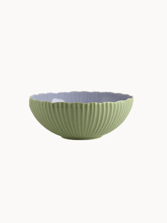 A two-toned ceramic bowl with a finely ribbed, mint  exterior and a smooth lavender interior, on a plain background.