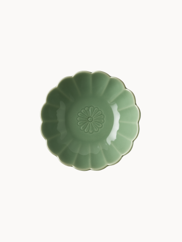 A top-down view on a small, sage green ceramic bowl designed in the shape of a blooming flower,  finished with a smooth glossy glaze, isolated on a plain white background.