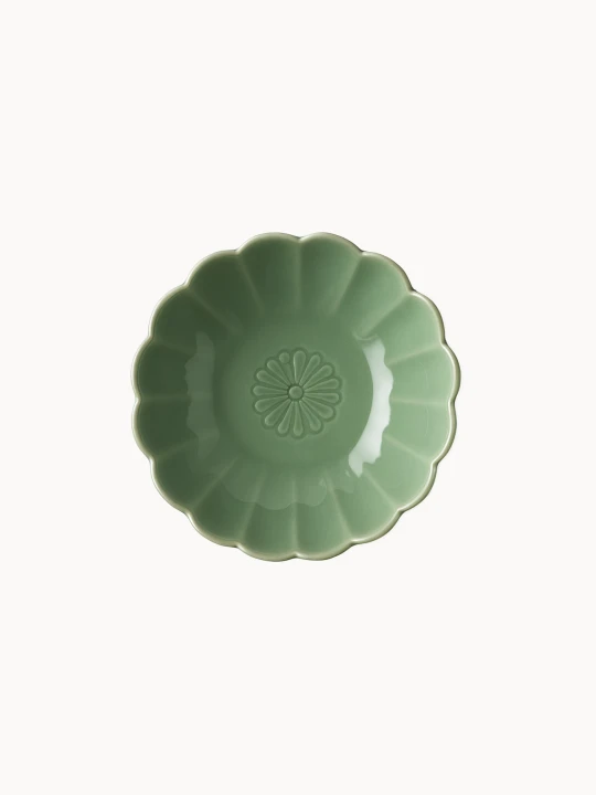 A top-down view on a small, sage green ceramic bowl designed in the shape of a blooming flower,  finished with a smooth glossy glaze, isolated on a plain white background.