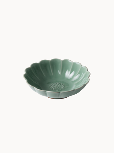 A small, sage green ceramic bowl designed in the shape of a blooming flower,  finished with a smooth glossy glaze, isolated on a plain white background.