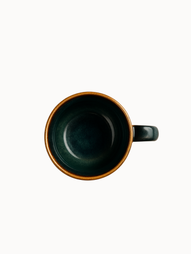 A top-down view on a ceramic mug with a rustic design, featuring a smooth glaze in shades of earthy green that fade into a natural brown base, on a plain white background.