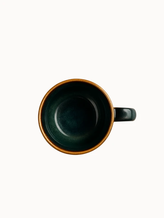 A top-down view on a ceramic mug with a rustic design, featuring a smooth glaze in shades of earthy green that fade into a natural brown base, on a plain white background.