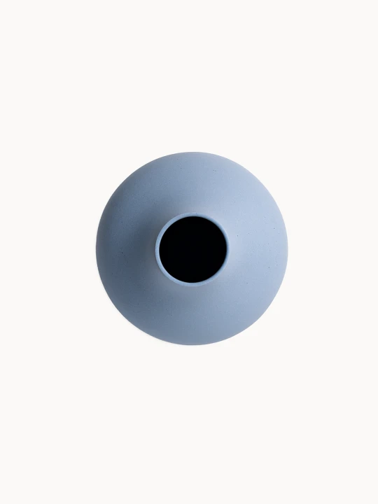 A  top-down view on a ceramic vase with a matte, textured light blue finish isolated on a plain white background.