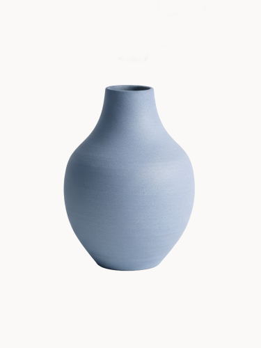 A ceramic vase with a matte, textured light blue finish isolated on a plain white background. It features a teardrop silhouette with a wide, rounded body that tapers upward into a narrow neck.