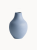 A ceramic vase with a matte, textured light blue finish isolated on a plain white background. It features a teardrop silhouette with a wide, rounded body that tapers upward into a narrow neck.