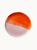 A top-down view on a ceramic cake stand, half glazed in glossy orange tone and half in a matte pastel pink.